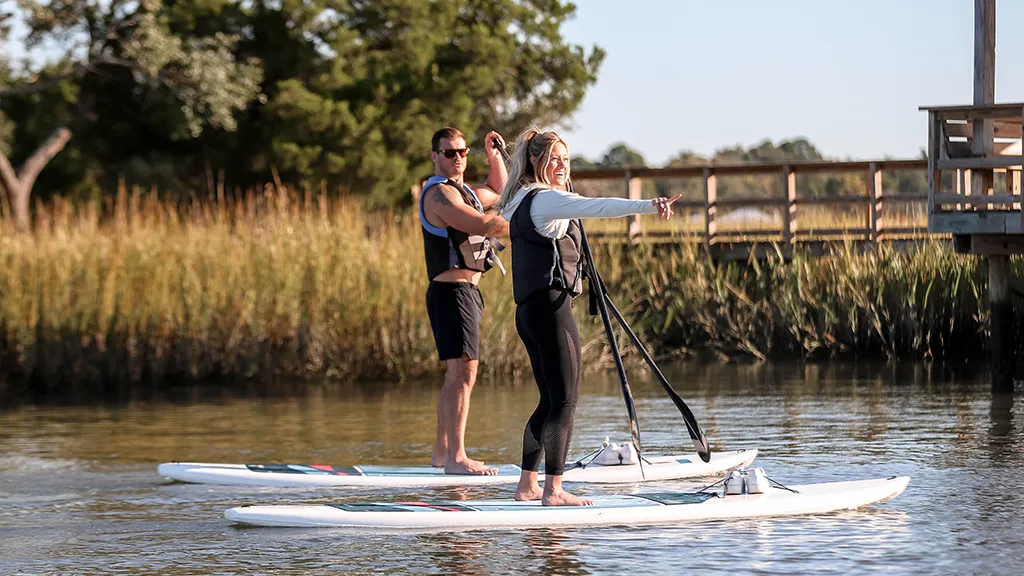 a man and a women paddle boarding