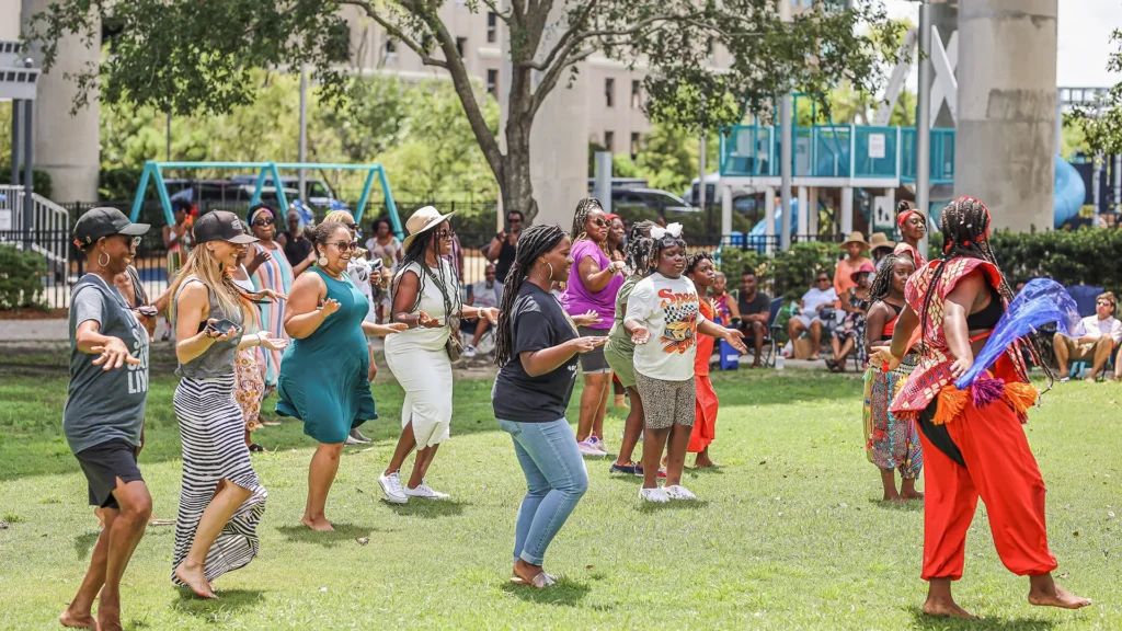 Women dancing in a field at the Sweetgrass Festival