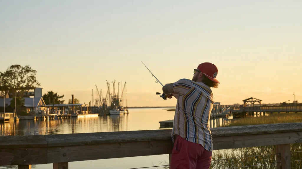 A man fishing at sunset at shem creek