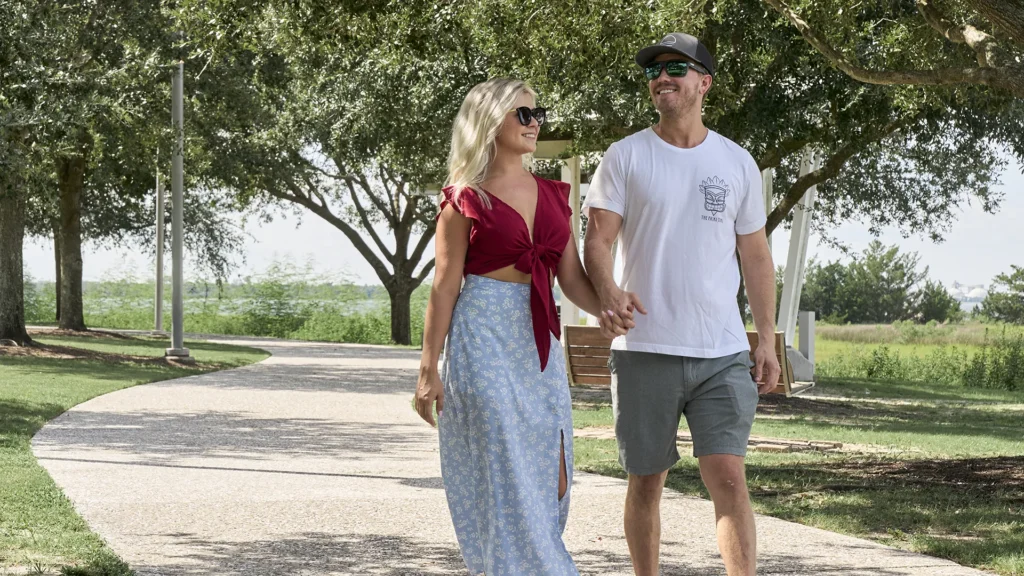 A couple holding hands walking together at the park